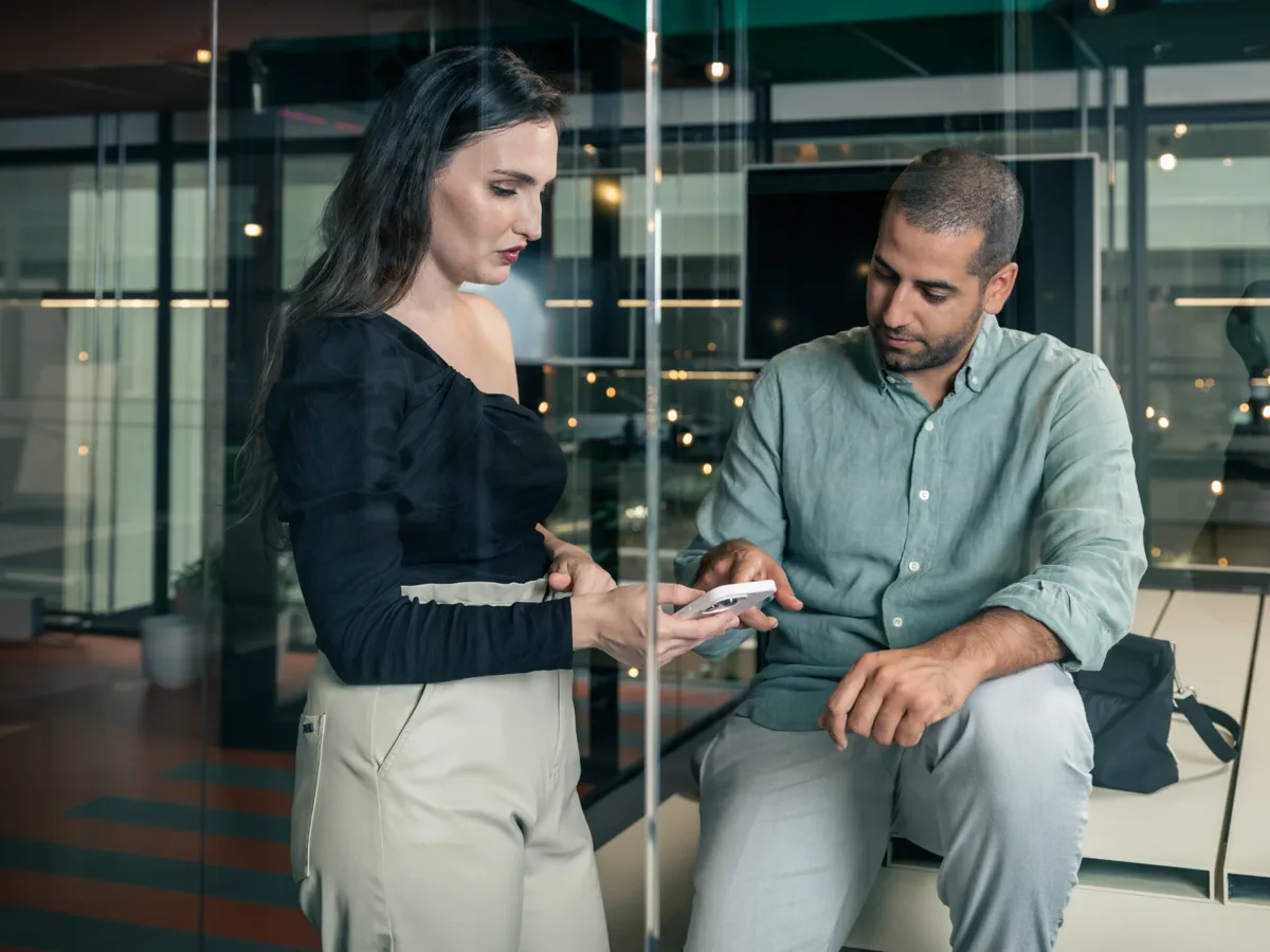 Twee collega’s bekijken samen een smartphone op het Boekhoudheld-kantoor in Rotterdam