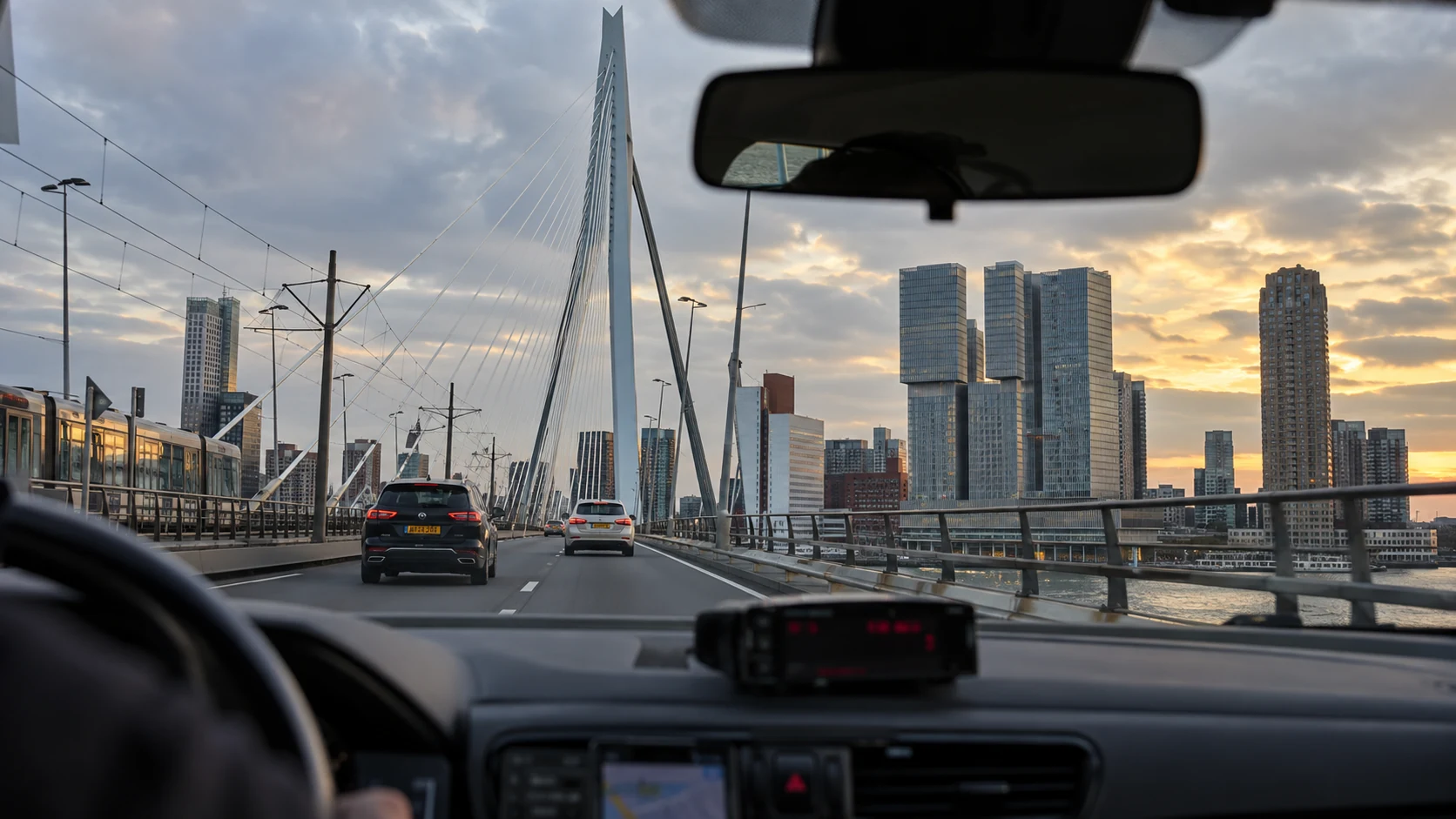 Taxirit over de Erasmusbrug met de Rotterdamse skyline in beeld
