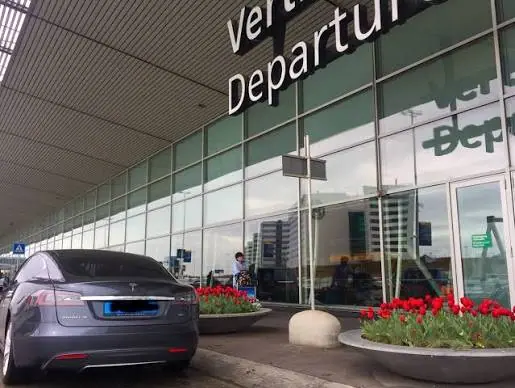 Taxi geparkeerd bij de vertrekhal van een luchthaven