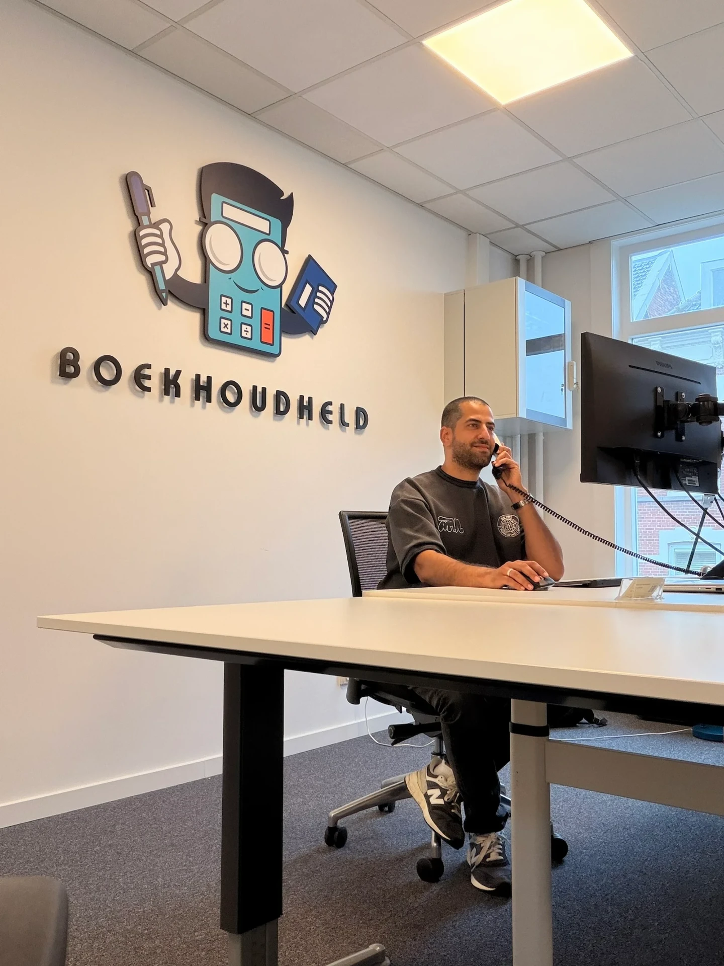 Anass Bounhilat aan de telefoon op het kantoor van Boekhoudheld in Rotterdam